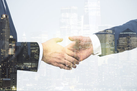 Handshake of two businessmen on modern city skyline background, deal and partnership concept....