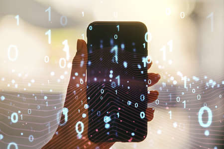 Creative abstract binary code hologram and hand with mobile phone on background, AI and machine learning concept. Multiexposureの写真素材