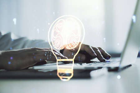 Creative light bulb illustration with human brain and with hands typing on computer keyboard on background, future technology concept. Multiexposureの写真素材