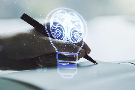 Creative idea concept with light bulb and human brain illustration with man hand writing in notebook on background. Neural networks and machine learning concept. Multiexposureの写真素材