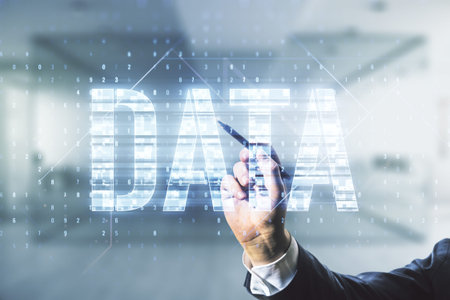 Man hand with pen writes Data word hologram on blurred office background, big data and blockchain...