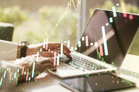 Abstract creative financial graph with hand typing on laptop on background, financial and trading...