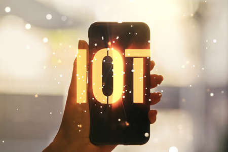 Double exposure of creative IOT hologram and hand with cell phone on background, research and development conceptの写真素材