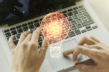 Creative light bulb illustration with hands typing on computer keyboard on background, future technology concept. Multiexposureの写真素材