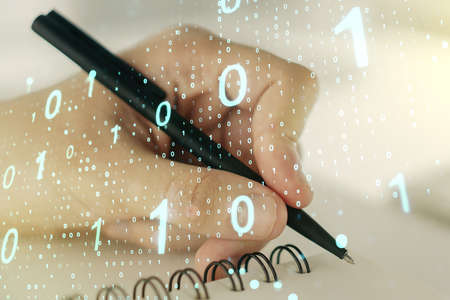 Creative abstract binary code sketch and man hand writing in notepad on background, hacking and matrix concept. Multiexposureの写真素材