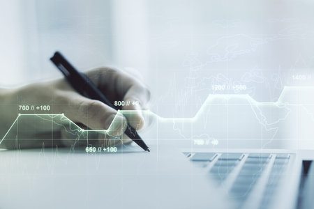 Abstract creative stats data concept with hand writing in notebook on background with laptop....