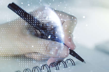 Multi exposure of abstract creative digital world map and man hand writing in notebook on background, tourism and traveling conceptの写真素材