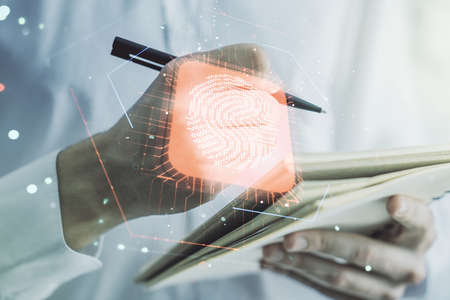 Multi exposure of abstract fingerprint scan interface with man hand writing in notepad on background, digital access conceptの写真素材