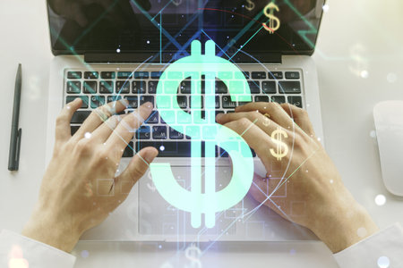 Creative concept of USD symbols illustration and hands typing on laptop on background. Trading and...