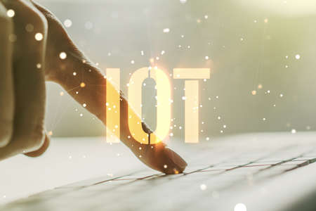 Creative IOT hologram with hands typing on computer keyboard on background, internet of things concept. Multiexposureの写真素材