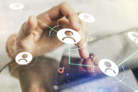 Double exposure of social network icons concept and hand working with a digital tablet on...