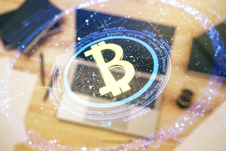 Double exposure of creative Bitcoin symbol with modern laptop on background. Cryptocurrency conceptの写真素材