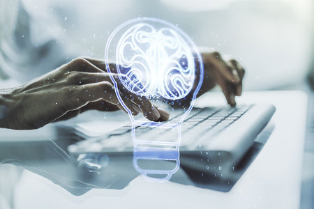 Creative light bulb with human brain hologram and with hands typing on computer keyboard on background, artificial Intelligence and neural networks concept. Multiexposureの写真素材