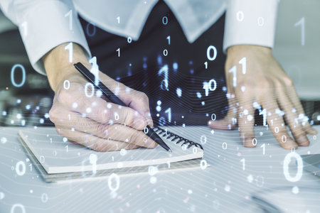 Creative abstract binary code hologram and hand writing in diary on background with laptop, AI and machine learning concept. Multiexposureの写真素材