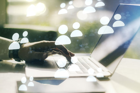 Double exposure of social network icons concept with hands typing on laptop on background. Marketing and promotion conceptの写真素材