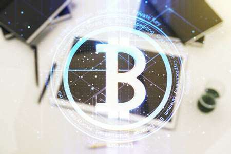 Double exposure of creative Bitcoin symbol hologram and modern digital tablet on background. Mining and blockchain conceptの写真素材