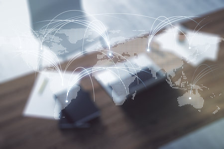 Double exposure of abstract digital world map with connections and modern desktop with laptop on background, research and strategy conceptの写真素材