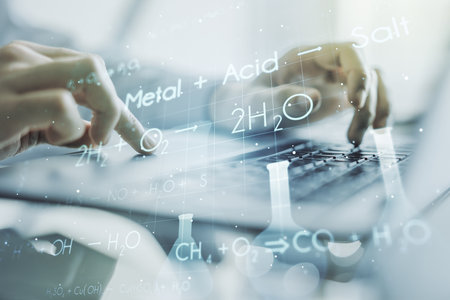 Double exposure of creative chemistry concept with hands typing on laptop on background, research and development conceptの写真素材