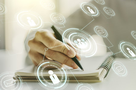 Double exposure of social network icons concept with man hand writing in notebook on background. Marketing and promotion conceptの写真素材