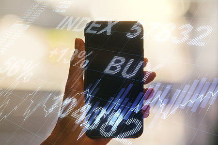 Multi exposure of abstract financial graph and hand with mobile phone on background, financial and trading conceptの写真素材