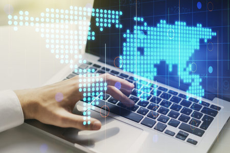 Abstract creative world map and hands typing on laptop on background, international trading concept....