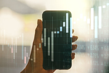 Abstract creative financial graph and hand with phone on background, forex and investment concept. Multiexposureの写真素材