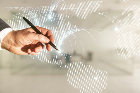 Double exposure of man hand with pen working with abstract digital world map hologram with connections on blurred office background, research and strategy conceptの写真素材