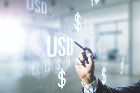 Man hand with pen working with virtual USD symbols illustration on blurred office background. Trading and currency concept. Multiexposureの写真素材