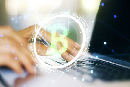 Creative Bitcoin concept with hands typing on computer keyboard on background. Double exposure