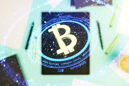Creative Bitcoin concept and modern digital tablet on desktop on background, top view. Double exposureの写真素材
