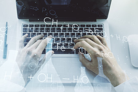 Creative chemistry concept with hands typing on laptop on background. Multiexposureの写真素材