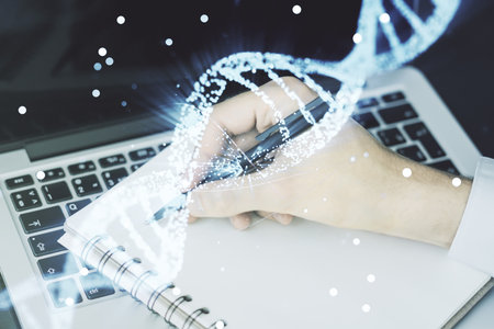 Double exposure of creative DNA hologram and hand writing in notebook on background with laptop. Bio Engineering and DNA Research conceptの写真素材