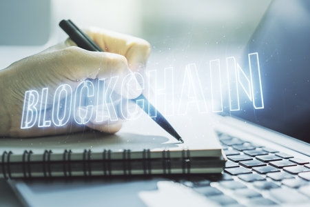 Creative abstract blockchain technology hologram and hand writing in diary on background with laptop, cryptography and decentralization concept. Multi exposureの写真素材