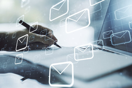 Creative concept of postal envelopes illustration with hand writing in notebook on background with laptop. Email and communications concept. Multiexposureの写真素材