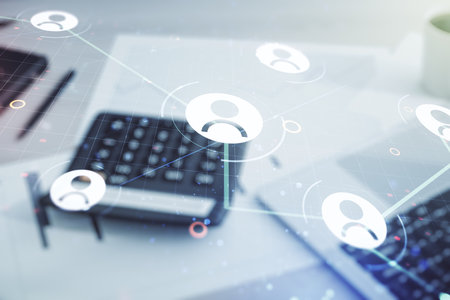 Double exposure of abstract virtual social network icons on blurry calculator with laptop background. Marketing and promotion conceptの写真素材