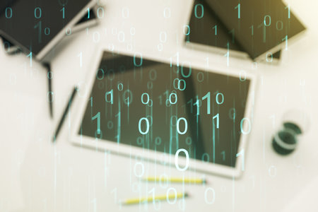 Creative abstract binary code hologram and modern digital tablet on desktop on background, top view, AI and machine learning concept. Multiexposureの写真素材
