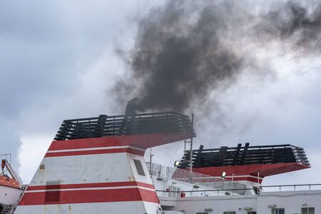 Ship chimneys expelling black smoke when starting enginesの写真素材