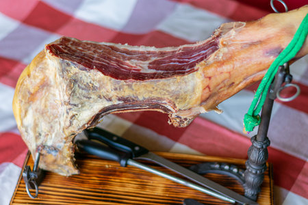 Serrano ham leg on a support made with horseshoes and a knife with a sharpener