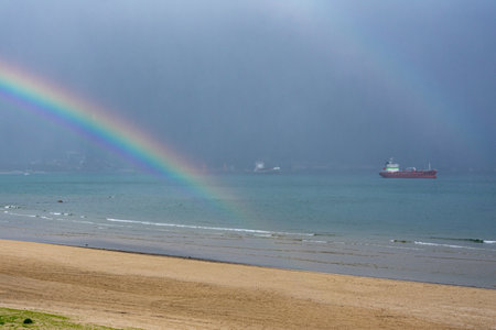 Rinconcillo beach in Algeciras on a winter day with the rainbow in the sky.の写真素材