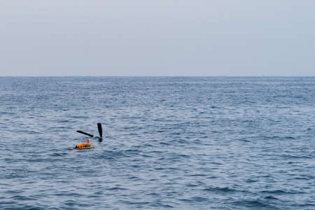 Diver's fins sticking out of the water while diving next to a diver's marker buoy.