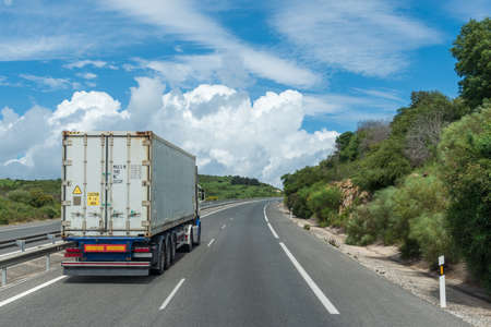 Truck transporting a container circulating on the highway.