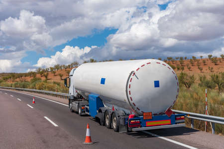 Tanker truck for transporting dangerous gases parked on the roadside with a blown out wheel.