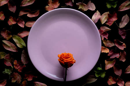 Cup of coffee, next to some dry autumn leaves around it.