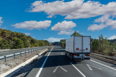 Truck with closed box and panels of dangerous goods of class 1, explosives.