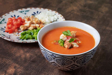 Gazpacho, typical Andalusian cold soup based on tomato, garlic, pepper and onion. On a dark wooden background.の写真素材