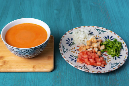 Gazpacho, cold soup typical of Andalusia based on tomato, garlic, pepper and onion. On a blue wooden background.の写真素材