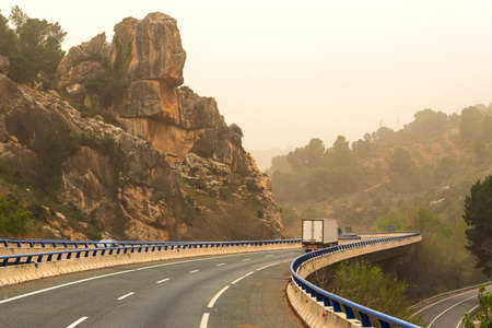 Refrigerated truck circulating through a viaduct in a gorge, a day with haze.の写真素材