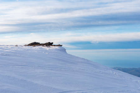 View from a summit of Sierra Nevada of some rocks in winter, with everything snowed.の写真素材