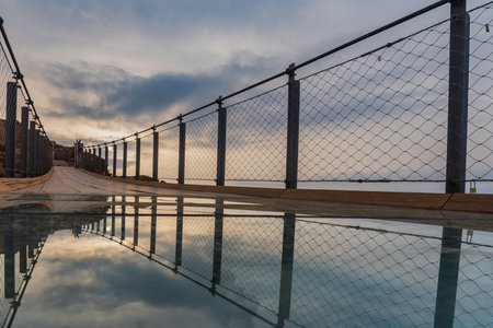 Jolucar suspension walkway, in Torrenueva Costa, Granada, view of the glass floor with the cloudy sky at dawn reflected.の写真素材