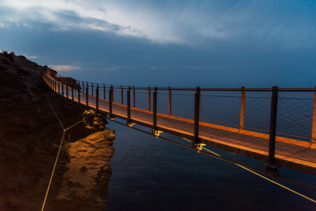 Jolucar suspension footbridge, in Torrenueva Costa, Granada, view of the footbridge before dawn with the wooden floor illuminated.の写真素材